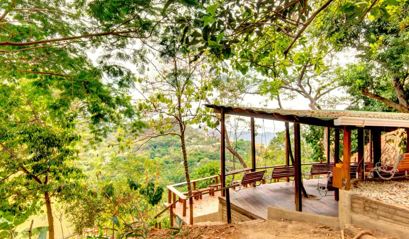 A covered shelter with benches in the lush forests of Minca, Colombia