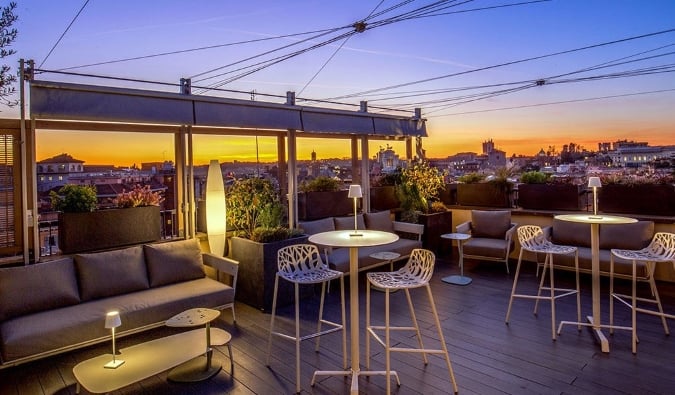 Rooftop bar and lounge with the cityscape in the background just after sunset at Monti Palace Hotel in Rome, Italy