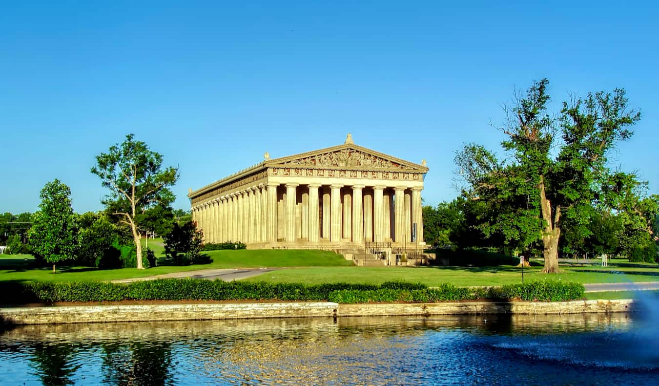 The Parthenon in Nashville, TN on a sunny summer day surrounded by greenery