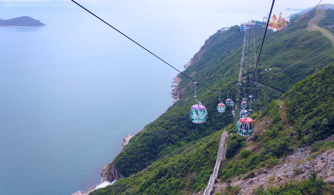 The Ngong Ping 360 cable car with views of the water and green mountains below, in Hong Kong