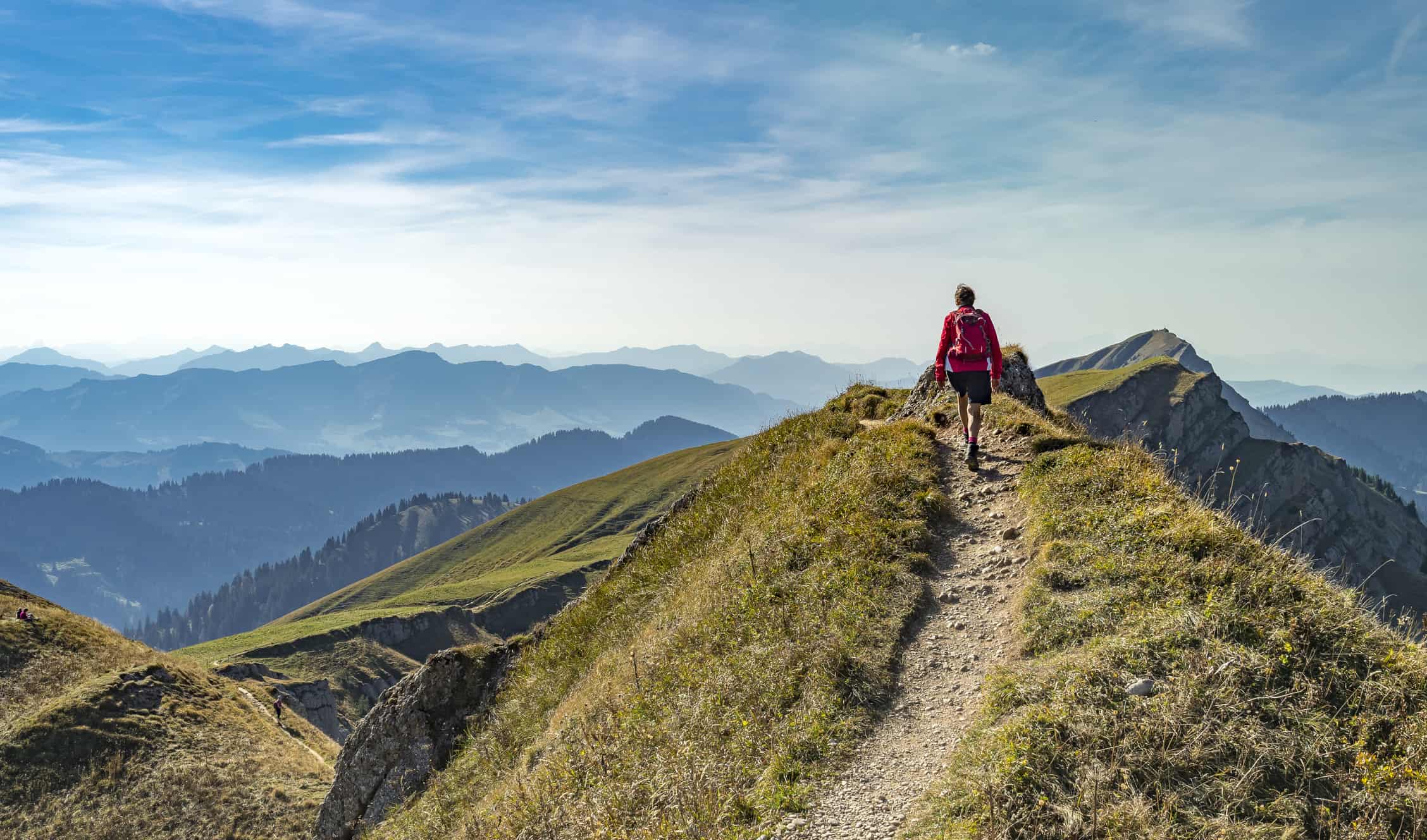 A woman hiking on a sunny day in the rugged mountains