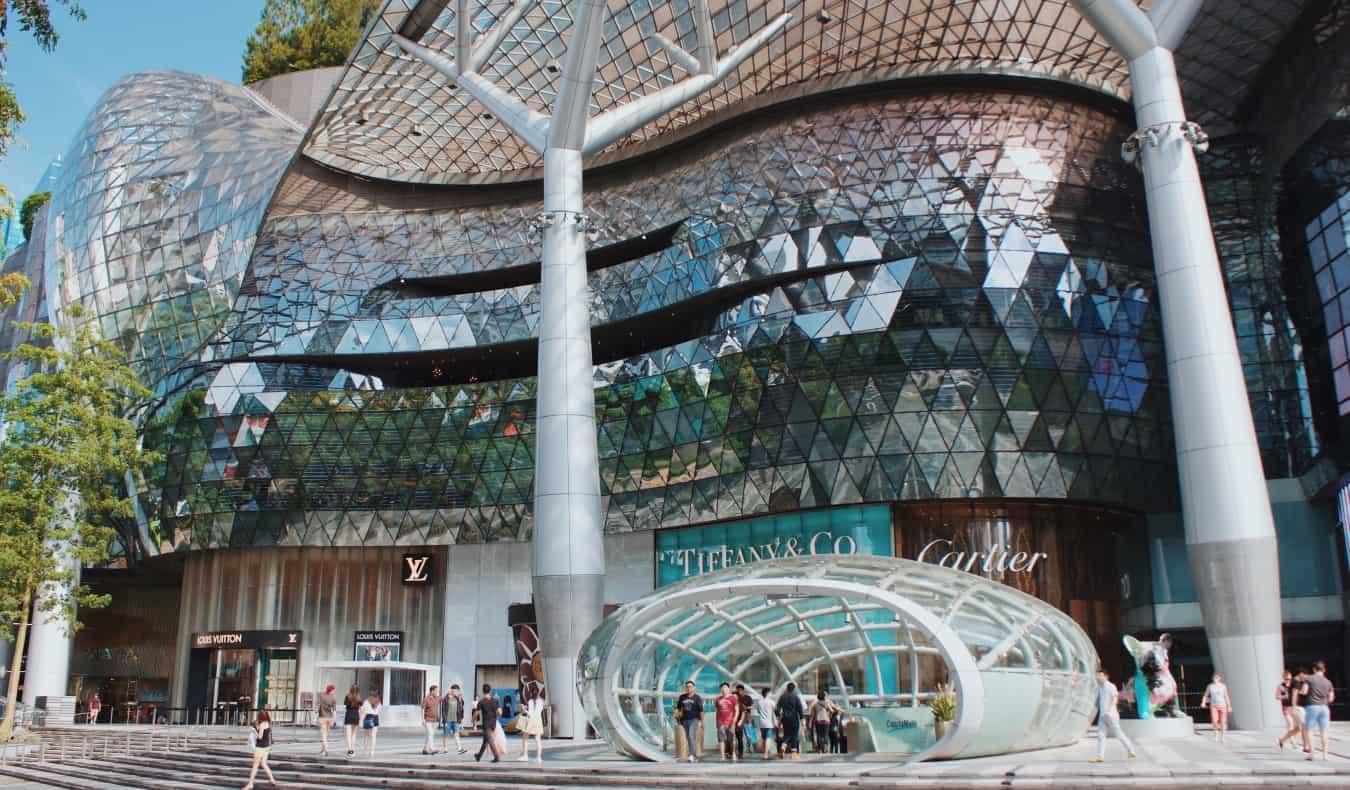 A modernly designed luxury shopping mall with signs for Cartier, Tiffany's, and Louis Vuitton in Orchard Road, Singapore