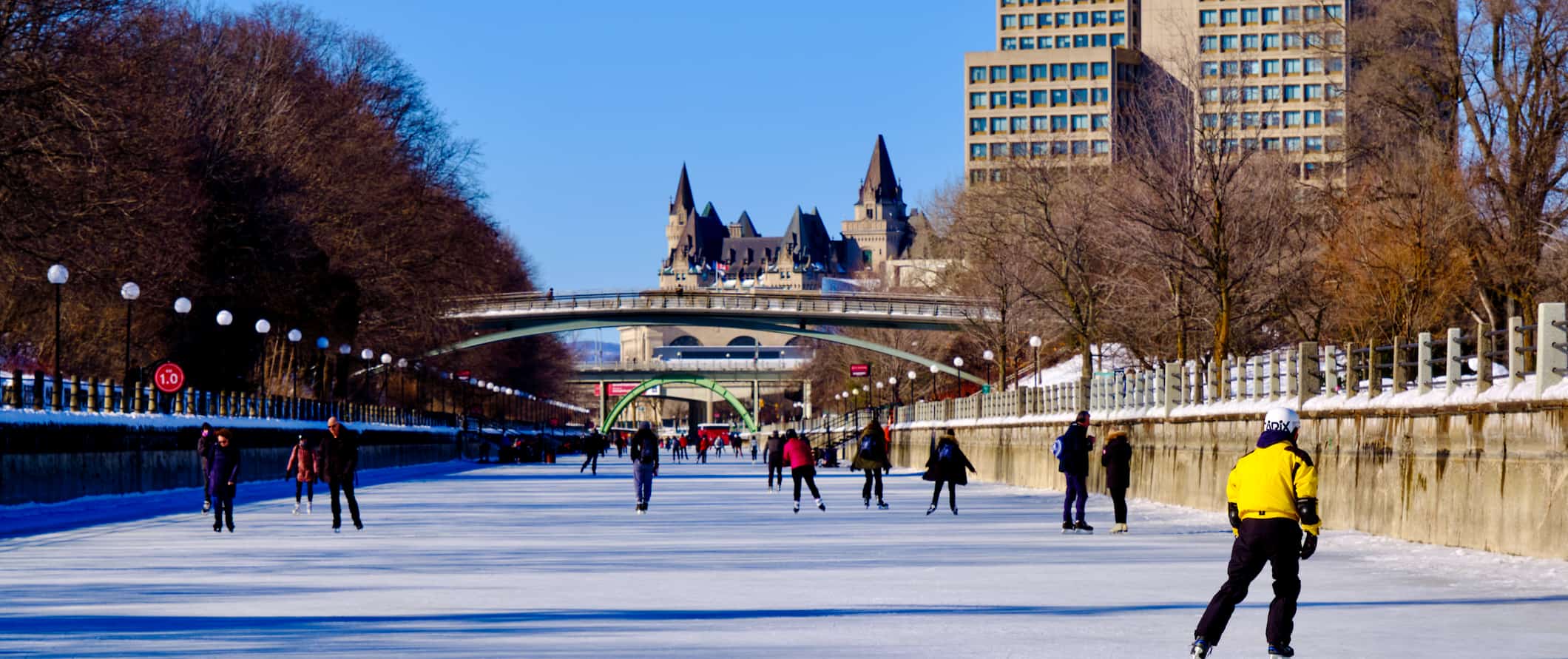 People skating on the frozen Rideau Canal in sunny Ottawa, Canada during the winter