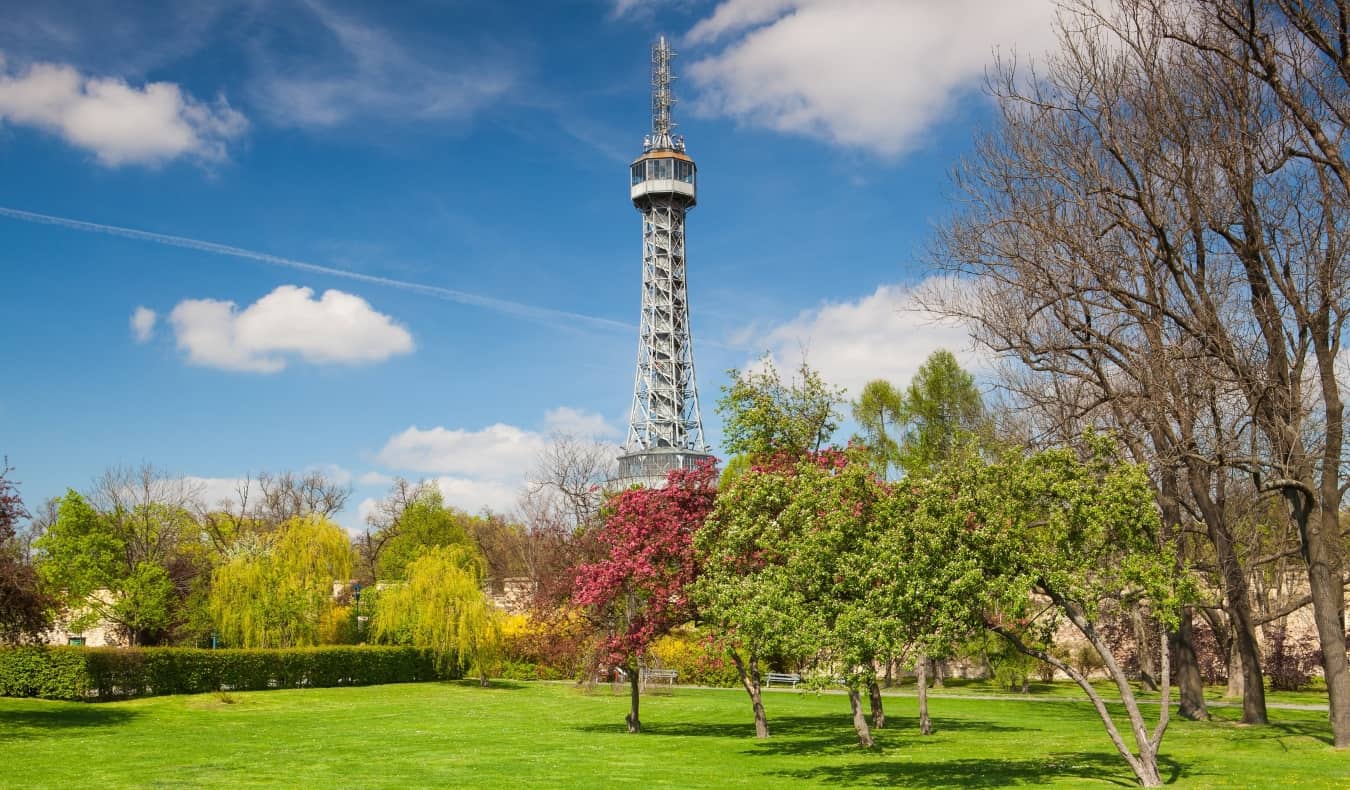 The steel Petrin Tower rising up from a tree-filled park in Prague, Czech Republic