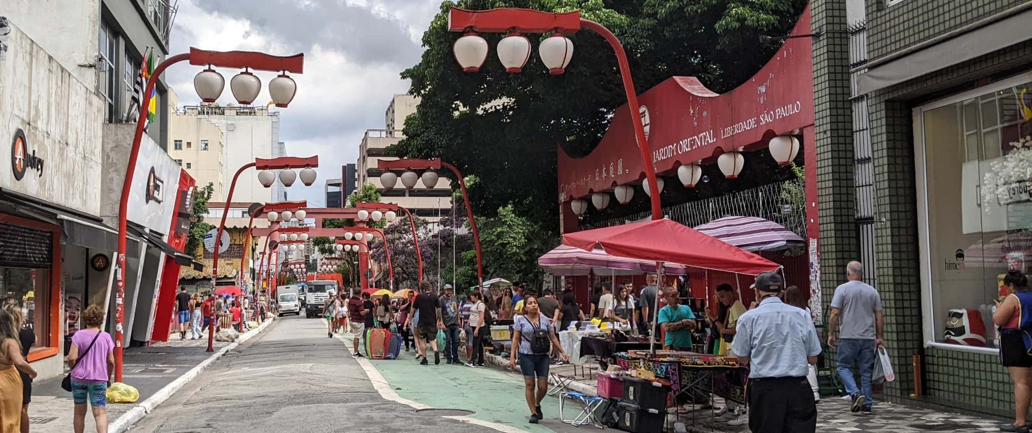 Streetscape with people walking around under colorful red lamps in Liberdade, the Japantown in São Paulo, Brazil