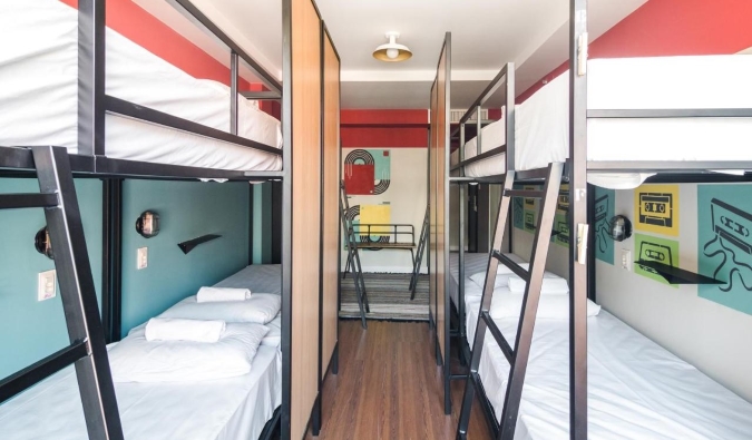 Metal bunk beds in a dorm room with colorful walls at Selina Lapa hostel in Rio de Janeiro, Brazil
