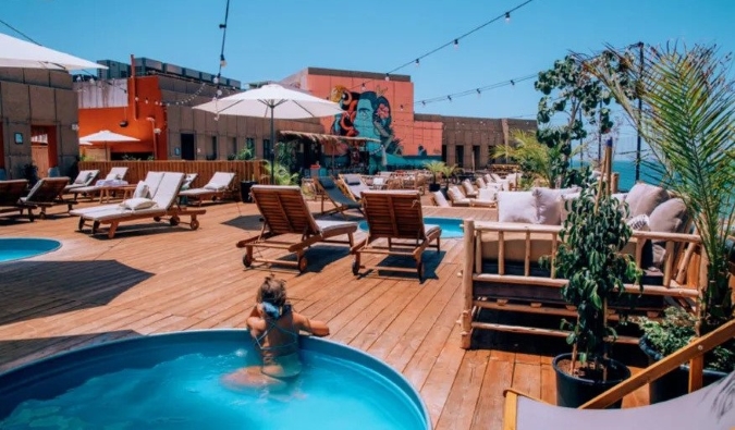 Woman lounging in the pool on the rooftop at the Selina hostel in Tel Aviv, Israel