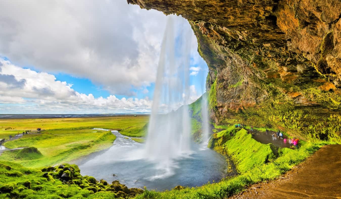 the huge and popular waterfall Seljalandsfoss near the rugged coast of Iceland