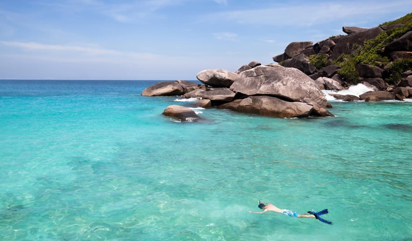 Man snorkels in the crystal clear waters in the Seychelles