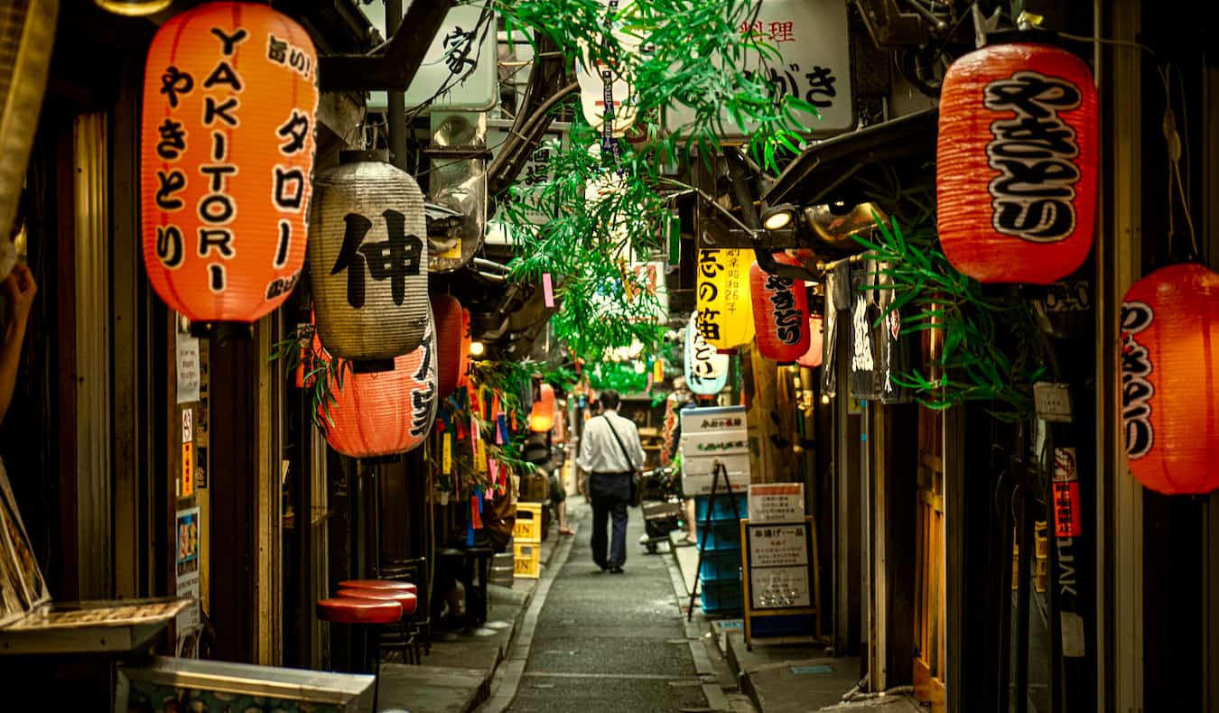 一位旅行者在日本东京新宿地区昏暗狭窄的小巷里探险