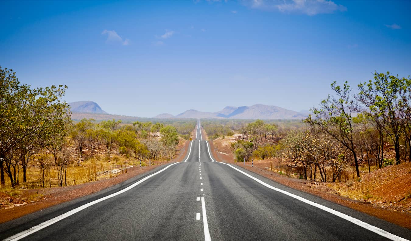 A wide open road in the Outback of Australia on a bright and sunny day