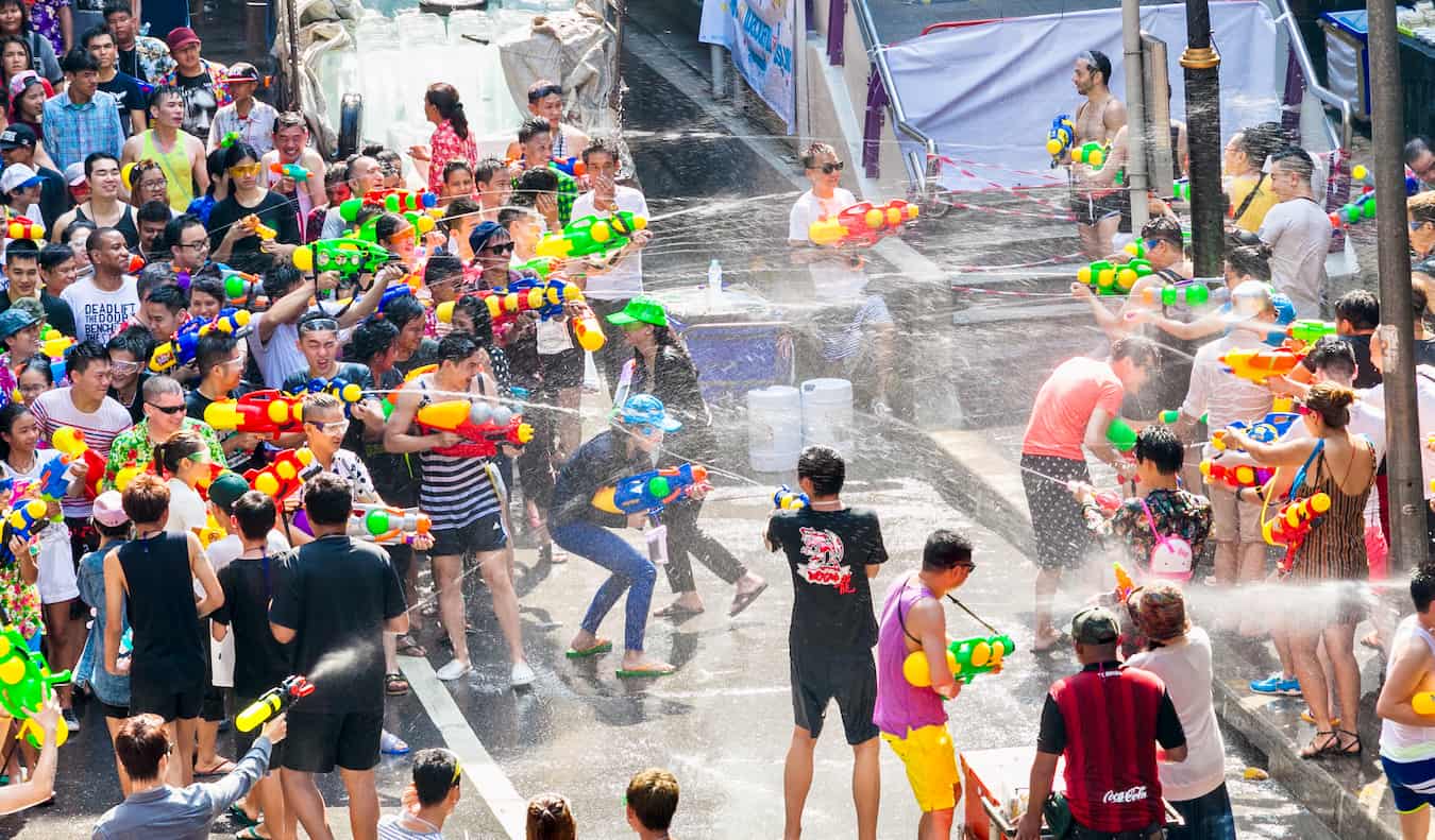 People shooting water guns and throwing water at each other during Songkran in Thailan