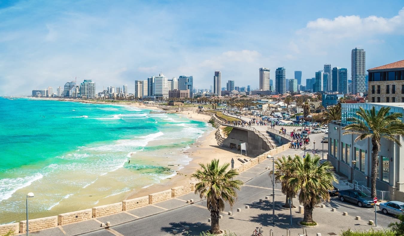 Les toits de la ville de Tel Aviv, en Israël, avec une plage en forme de fer à cheval, l'océan bleu azur et des gratte-ciel en arrière-plan