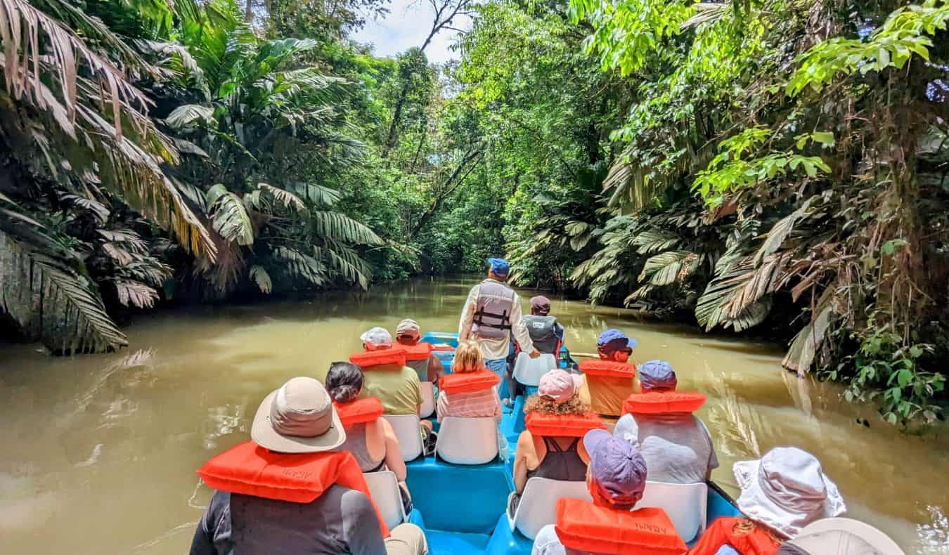 uma excursão em grupo da TNN descendo um rio estreito na selva