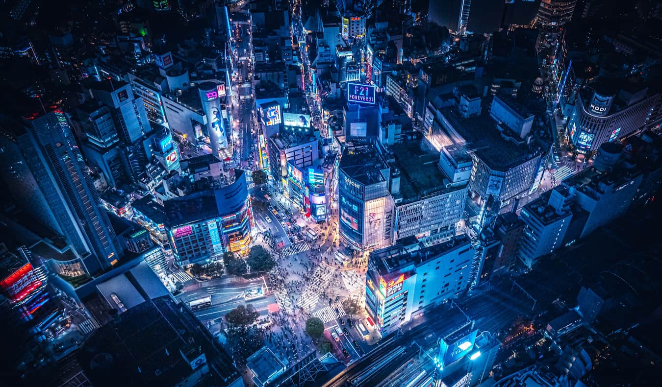 the busy streets of Tokyo at night at the bustling Shibuya Crossing