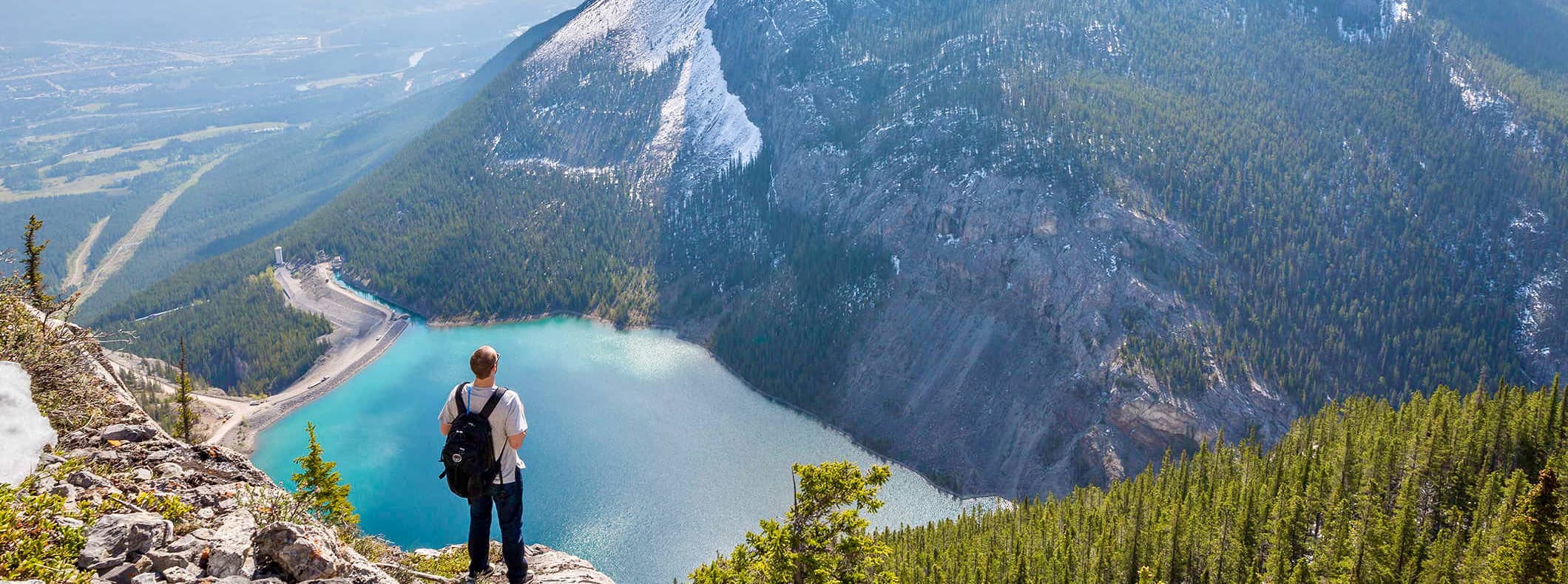 独自一人的徒步旅行者欣赏着远处的湖泊，眺望加拿大的群山