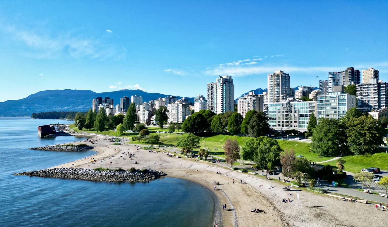 the stunning skyline of Vancouver, Canada as seen from above at sunset with mountains in the distance