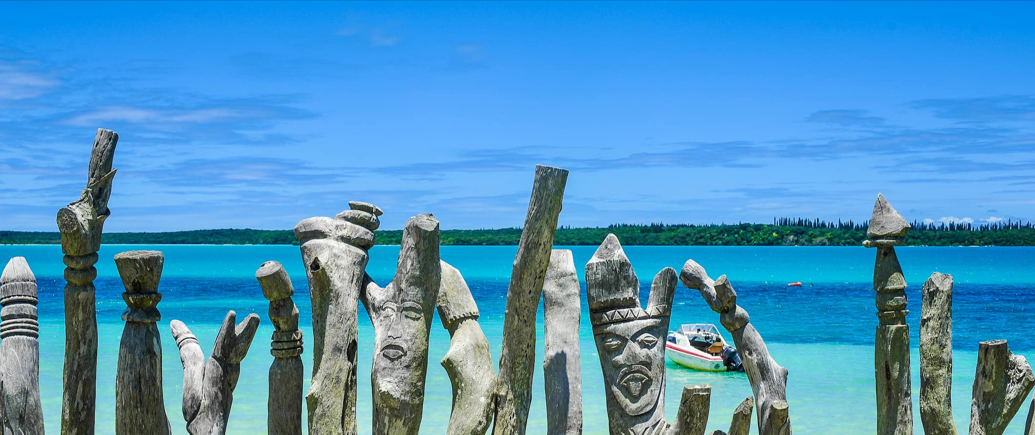 Carved wooden posts near the beach in sunny, bright Vanuatu