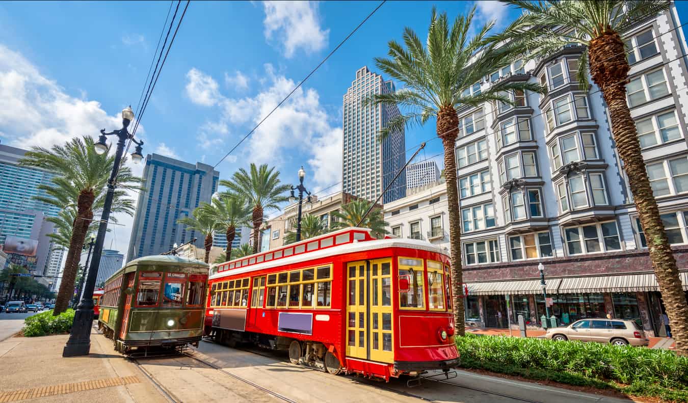 A bright red streetcar driving around sunny New Orleans, USA