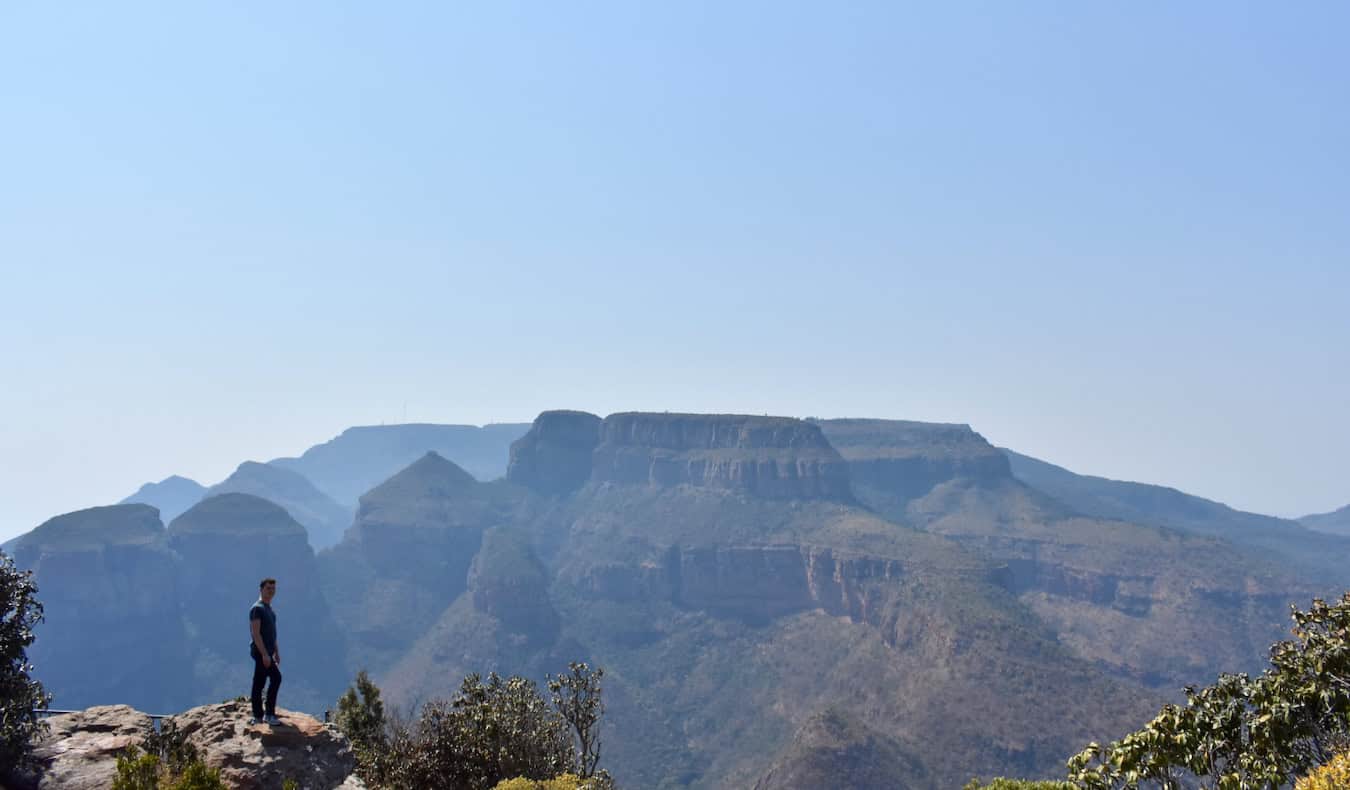 Nomadic Matt standing on a huge mountain in rugged South Africa