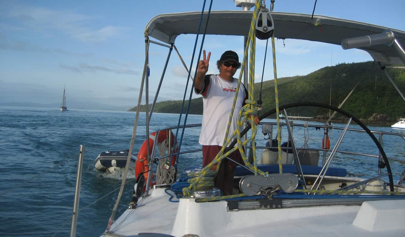 A man making a peace sign on a boat on the Whitsunday Islands in Australia