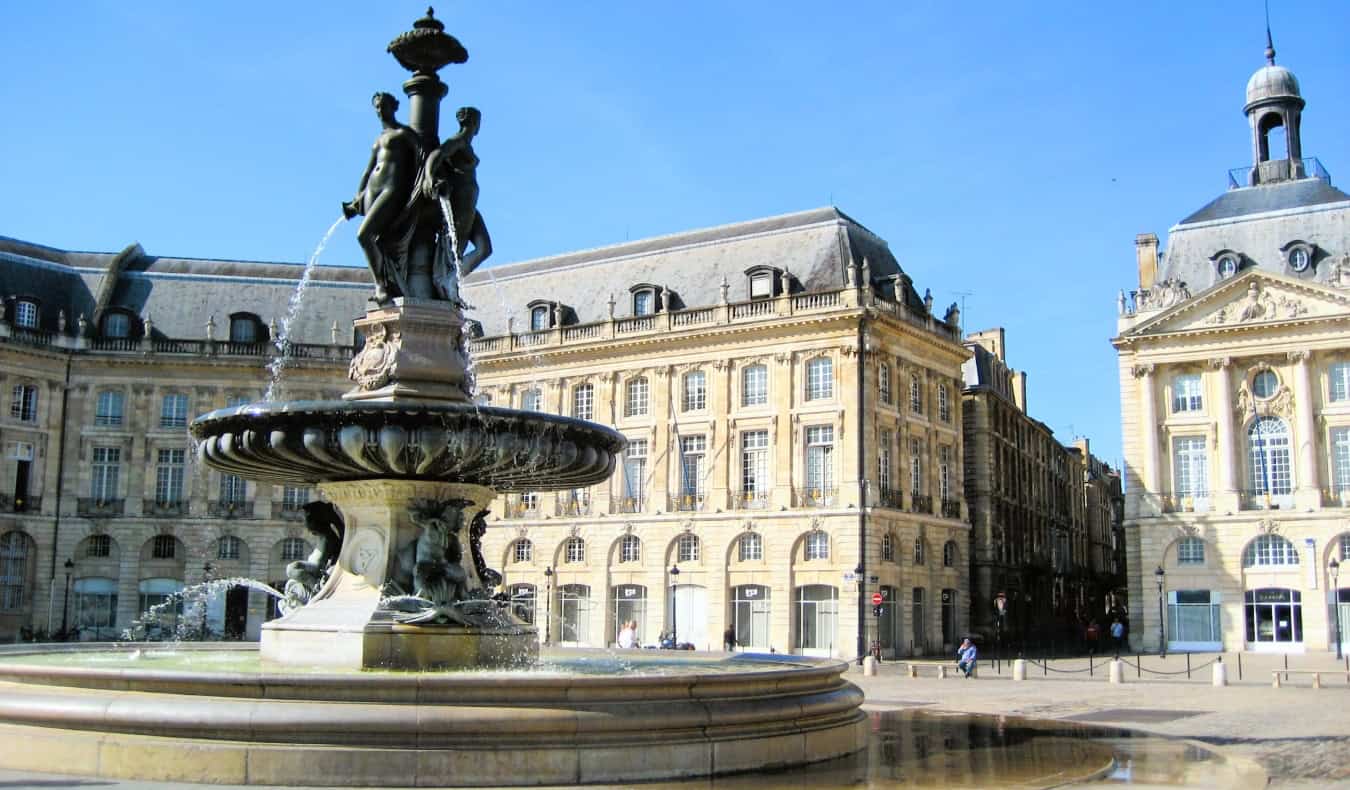 A fountain with several statues on it in sunny Bordeaux, France