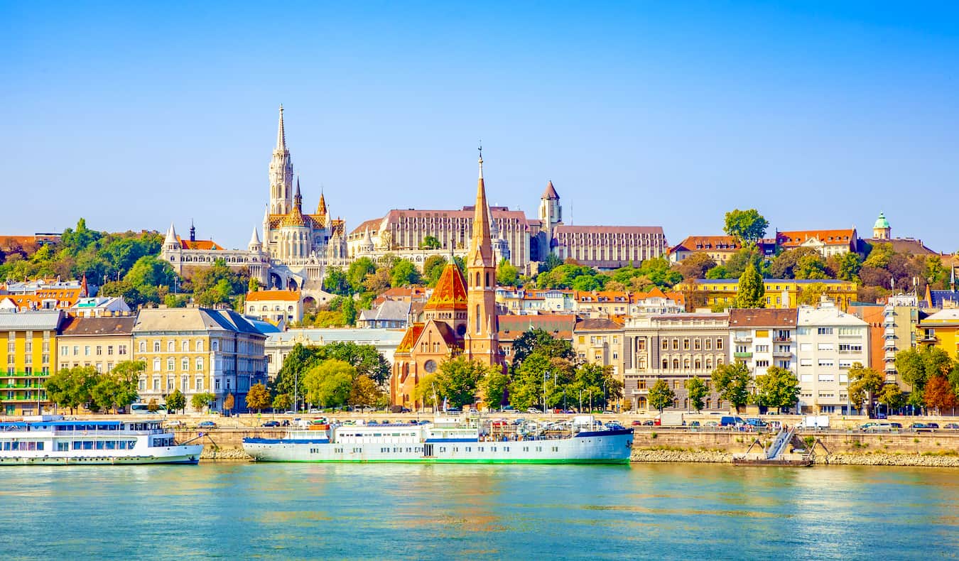 The skyline of Budapest, Hungary during a bright and sunny summer day as seen from over the Danube