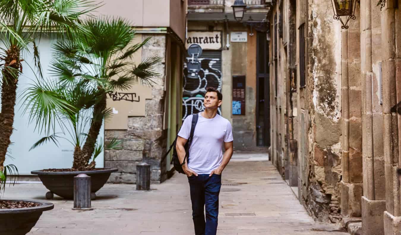 Nomadic Matt posing for a photo in a narrow alley in Barcelona, Spain