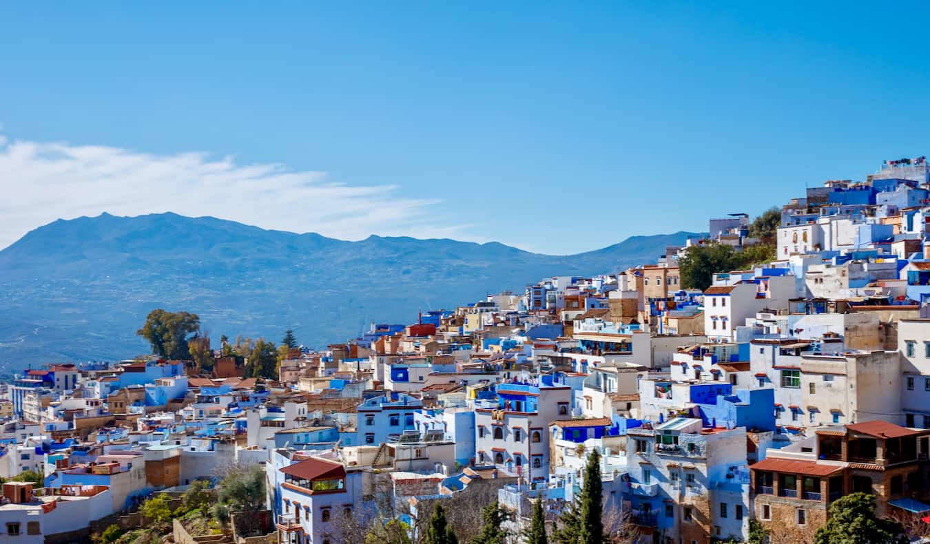 A view looking over the blue roofs of Chefchaouen in sunny Morocco