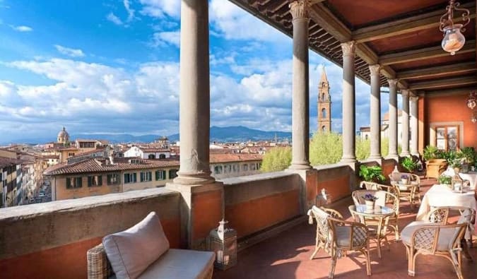 Rooftop terrace with chairs and table overlooking Florence, Italy cityscape at Hotel Palazzo Guadagni