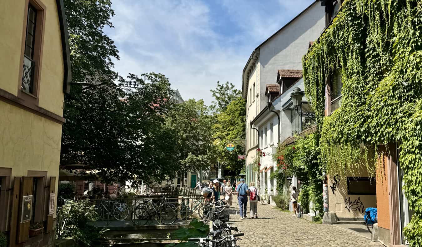 Pessoas explorando as ruas tranquilas de Freiburg em um dia ensolarado na Alemanha