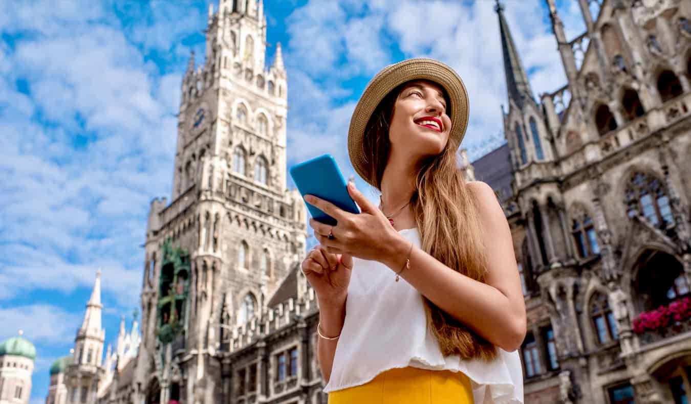 A solo female traveler using her eSIM and smartphone while traveling Europe