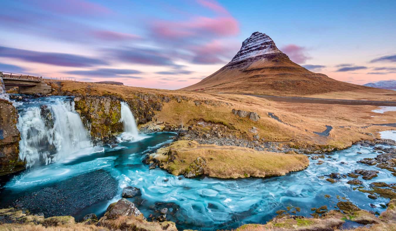 The famous Kirkjufell mountain in Iceland at sunset standing tall amongst the rugged scenery