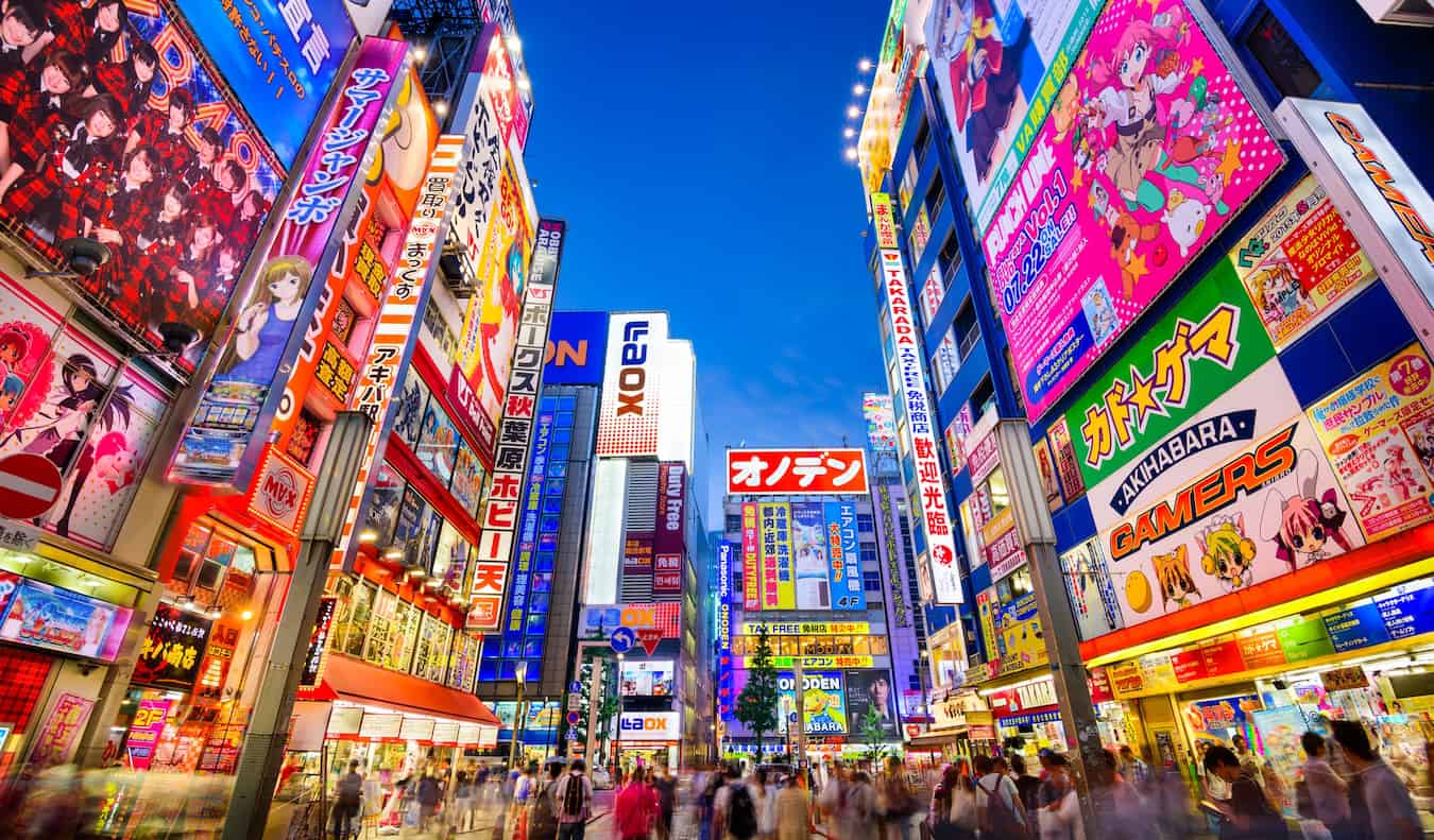 A bright and bustling street lit up at night with neon signs in Tokyo, Japan