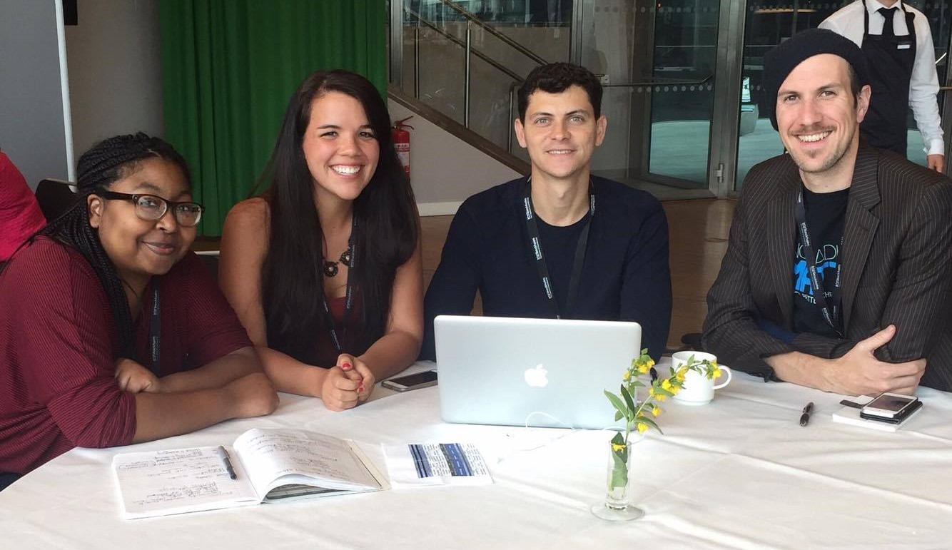 Nomadic Matt sitting around a table with past and present team members all working on their laptops