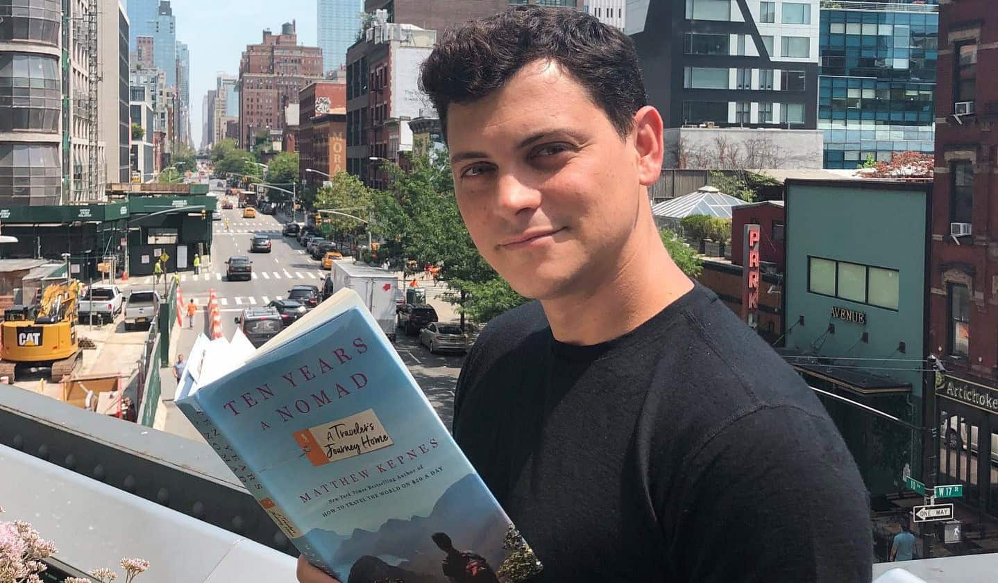 Nomadic Matt holding a copy of his book, How to Travel the World on $50 a day
