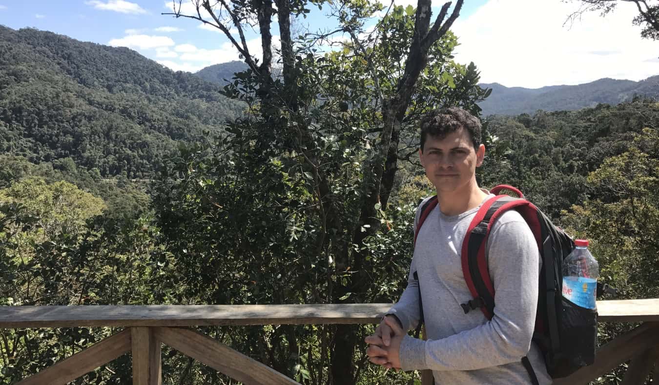 Nomadic Matt with a backpack in front of lush greenery