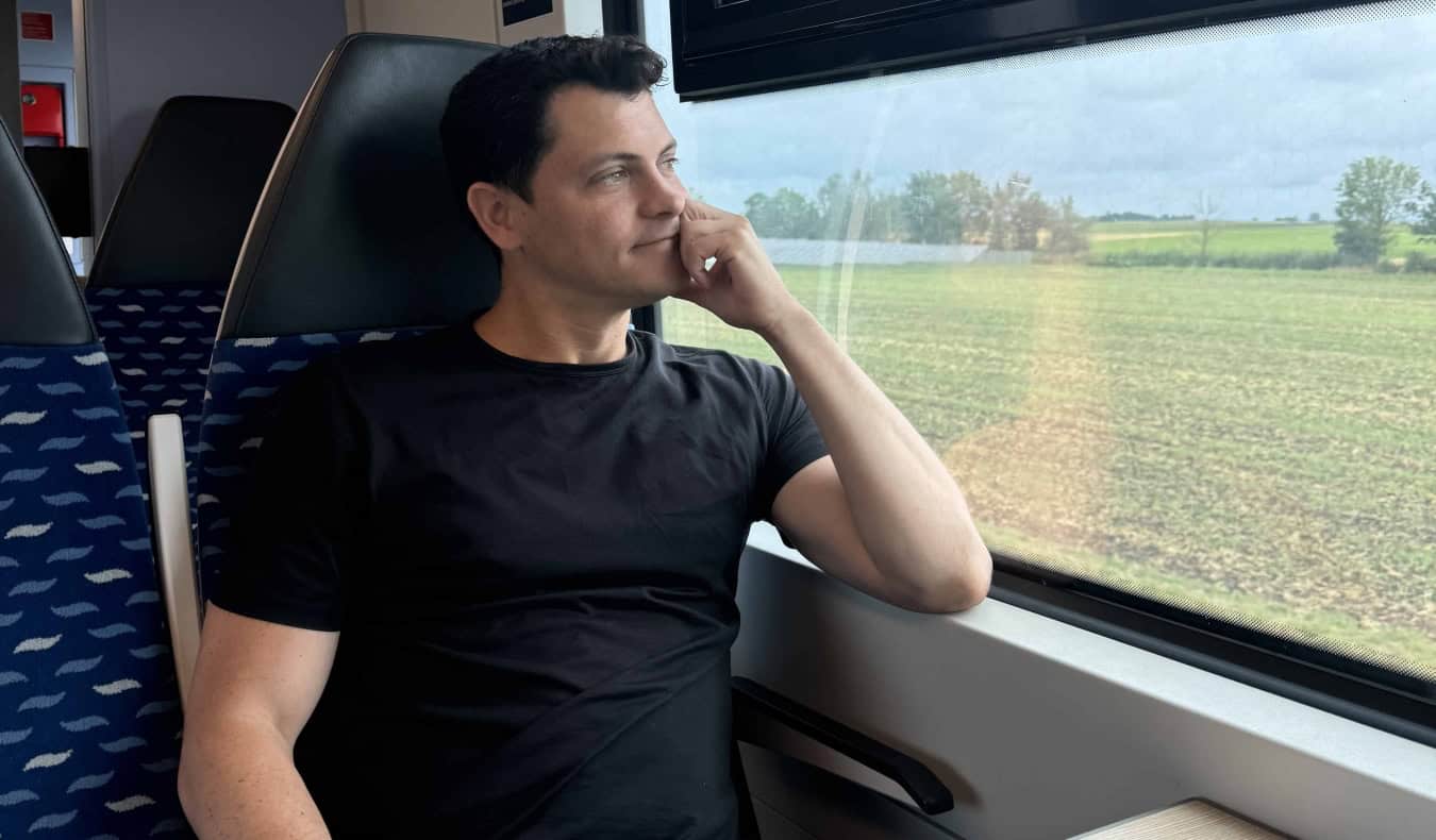 Nomadic Matt looking out the window on a train