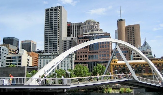 Melbourne skyline as viewed in back of an arched pedestrian bridge