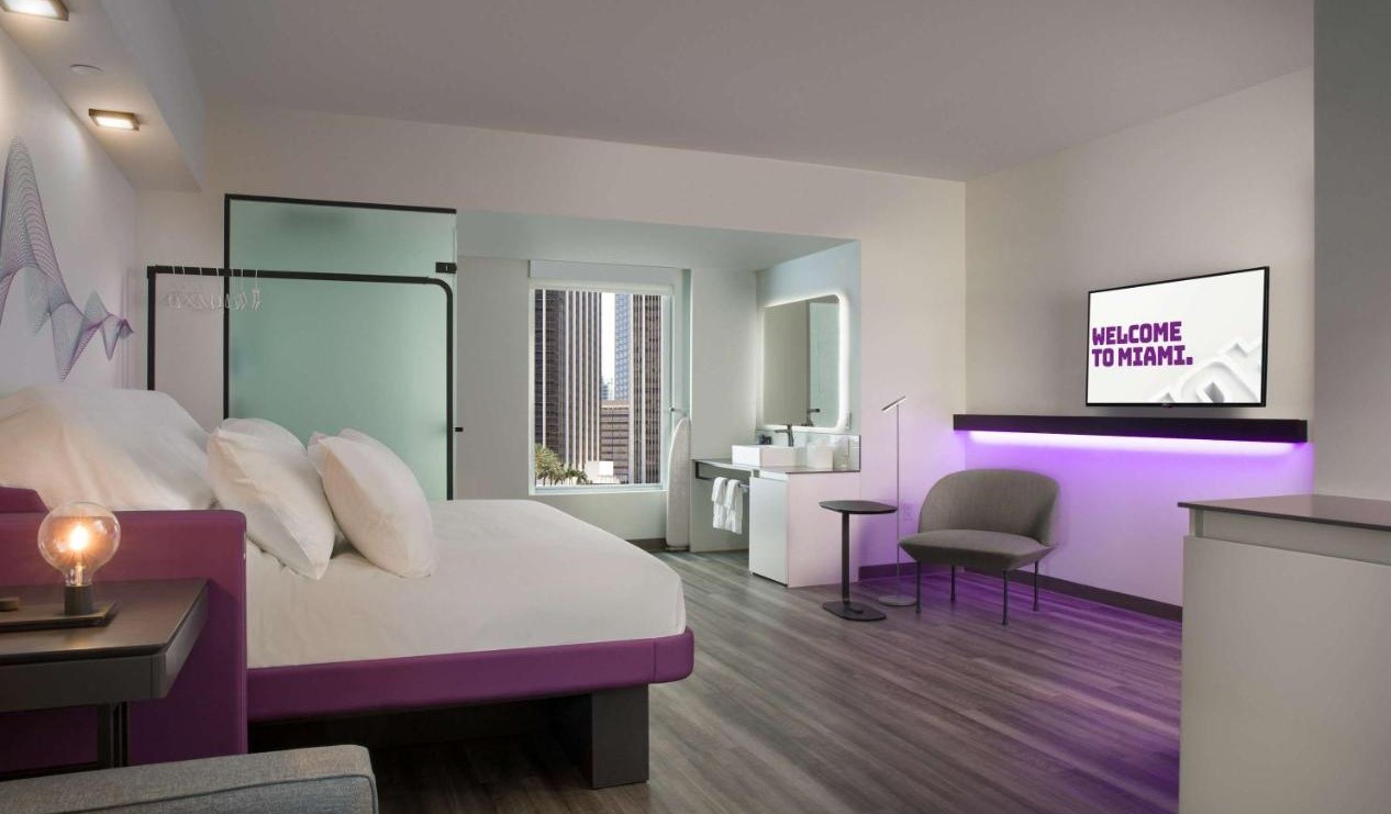 Dhomë hoteli e dizajnuar minimalisht me ngjyra të theksuara vjollce në të gjithë Yotel në Miami, Florida