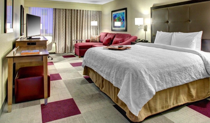 Basic hotel room with a queen sized bed, decorated in grey and purple at the Hampton Inn Miami-Coconut Grove/Coral Gables