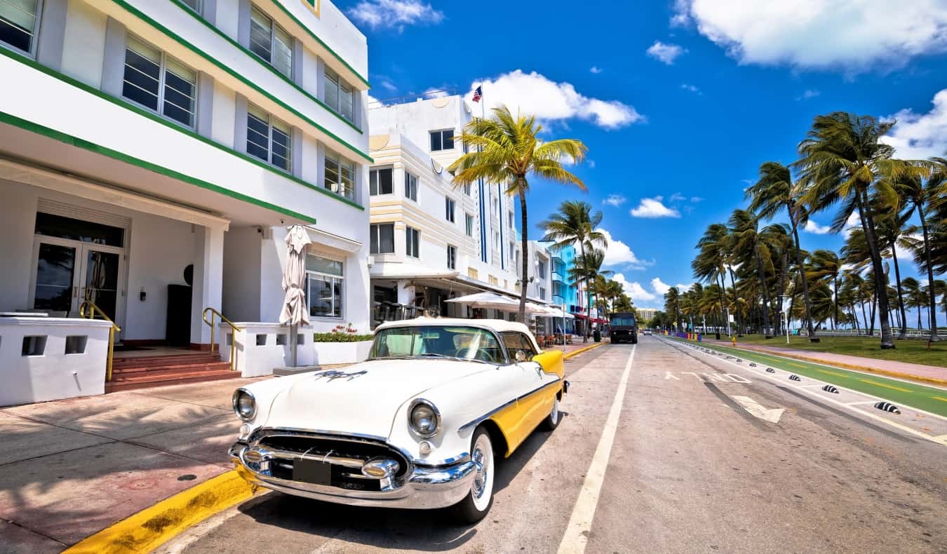 A colorful old 1960s car on the street in front of the Art Deco buildings of South Beach in Miami, Florida