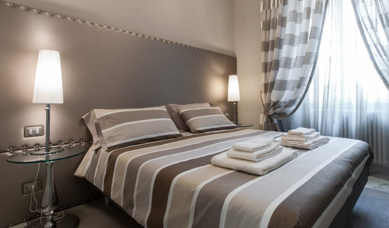 A double bed in a hotel room decorated in minimalist style with different shades of gray at Brera Prestige B&B, a hotel in Milan, Italy