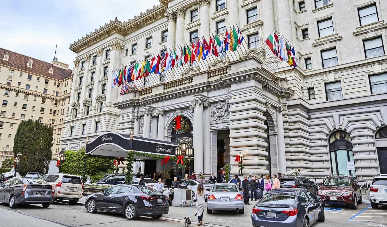 The stately Fairmont Hotel in Nob Hill, San Francisco, with dozens of country flags flying and luxury cars parked out front