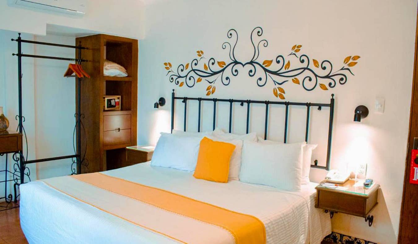 Un grand lit confortable dans une chambre simple de l'hôtel Oaxaca Real à Oaxaca, au Mexique.