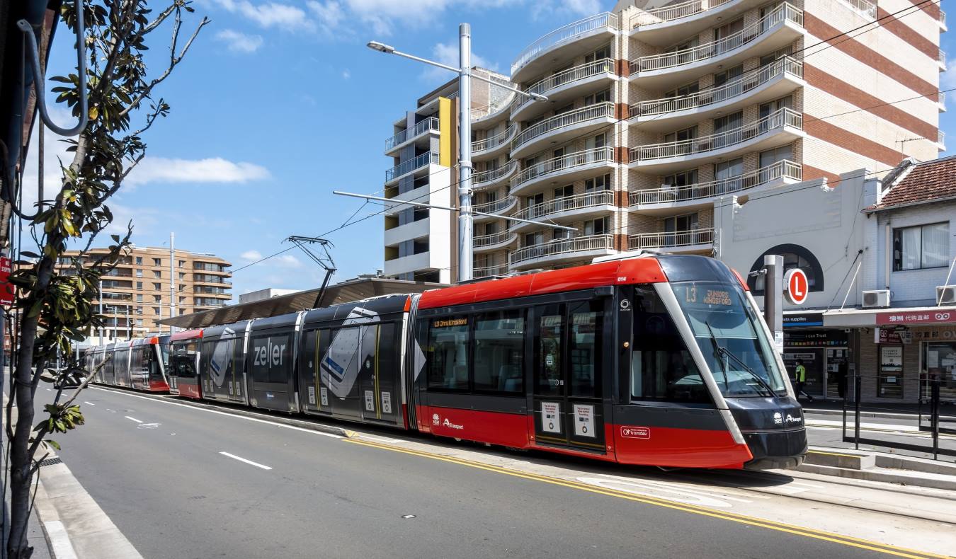 A tram drives down a street in Sydney, Australia