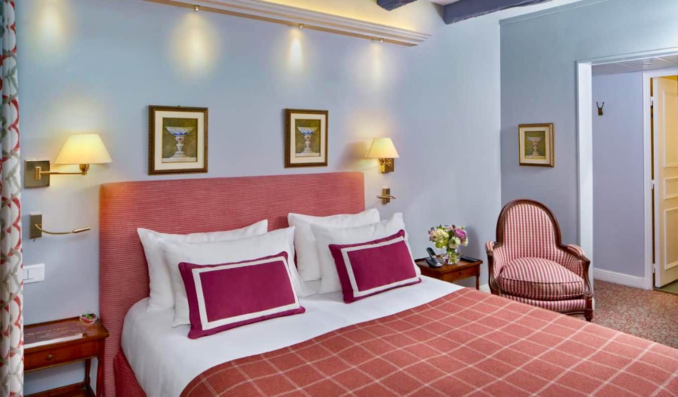 A colorful hotel room with antique touches at the Le Relais hotel in Paris, France