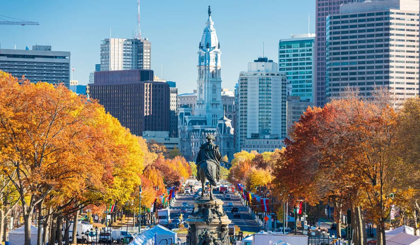 View down Benjamin Franklin Parkway lined with trees with orange leaves in Philadelphia, Pennsylvania