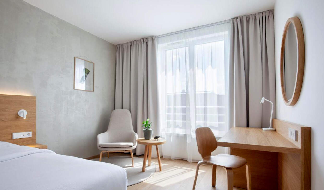 An all-white hotel room with lots of natural light at Botanique Hotel in Prague, Czechia