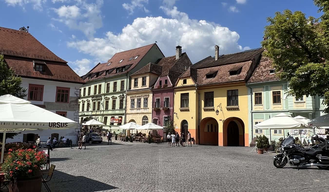 A historic, cobblestoned plaza in Sighisoara, Romania